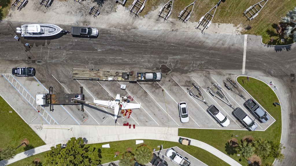 A Piper Twin Comanche PA-39 (PA-30 variant) at a boat ramp in Boca Raton, FL, being prepared to be removed by a crane after landing in the ocean, Aug. 23, 2026. (Photo: Boca Daily News)