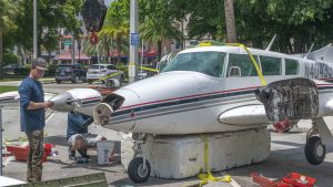 A Piper Twin Comanche PA-39 (PA-30 variant) at a boat ramp in Boca Raton, FL, being prepared to be removed by a crane after landing in the ocean, Aug. 23, 2026. (Photo: Boca Daily News)
