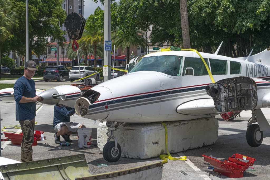 A Piper Twin Comanche PA-39 (PA-30 variant) at a boat ramp in Boca Raton, FL, being prepared to be removed by a crane after landing in the ocean, Aug. 23, 2026. (Photo: Boca Daily News)