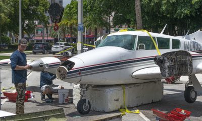 A Piper Twin Comanche PA-39 (PA-30 variant) at a boat ramp in Boca Raton, FL, being prepared to be removed by a crane after landing in the ocean, Aug. 23, 2026. (Photo: Boca Daily News)