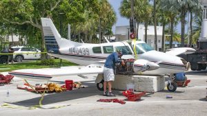 A Piper Twin Comanche PA-39 (PA-30 variant) at a boat ramp in Boca Raton, FL, being prepared to be removed by a crane after landing in the ocean, Aug. 23, 2026. (Photo: Boca Daily News)