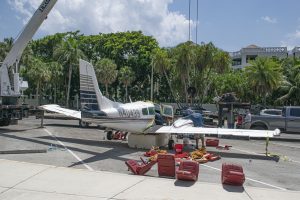A Piper Twin Comanche PA-39 (PA-30 variant) at a boat ramp in Boca Raton, FL, being prepared to be removed by a crane after landing in the ocean, Aug. 23, 2026. (Photo: Boca Daily News)