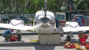 A Piper Twin Comanche PA-39 (PA-30 variant) at a boat ramp in Boca Raton, FL, being prepared to be removed by a crane after landing in the ocean, Aug. 23, 2026. (Photo: Boca Daily News)