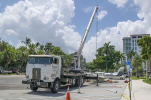 A Piper Twin Comanche PA-39 (PA-30 variant) at a boat ramp in Boca Raton, FL, being prepared to be removed by a crane after landing in the ocean, Aug. 23, 2026. (Photo: Boca Daily News)
