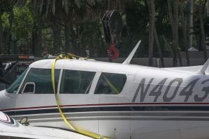 A Piper Twin Comanche PA-39 (PA-30 variant) at a boat ramp in Boca Raton, FL, being prepared to be removed by a crane after landing in the ocean, Aug. 23, 2026. (Photo: Boca Daily News)