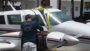 A Piper Twin Comanche PA-39 (PA-30 variant) at a boat ramp in Boca Raton, FL, being prepared to be removed by a crane after landing in the ocean, Aug. 23, 2026. (Photo: Boca Daily News)